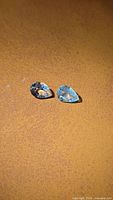 Both aquamarine gemstones side by side on surface