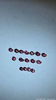 Group of loose round pink sapphires on light background