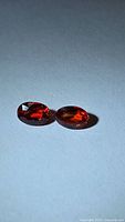 Pair of oval orange-red sapphires side by side