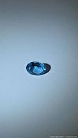 Front view of oval blue gemstone on neutral background