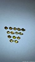 Group of 14 round yellow gemstones on light background