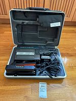 Open carry case showing camcorder, adapter, charger, cables
