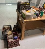 Workbench showing multiple crates and totes of assorted hardware