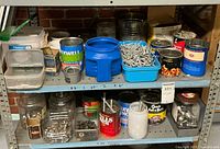 Shelf with multiple jars and cans containing various fasteners