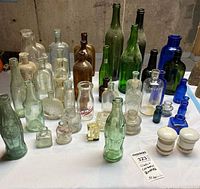Wide view of assorted glass bottles and porcelain insulators on table