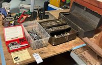 Toolbox open with trays, Blackhawk kit, plastic bin of hardware on workbench