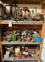 Overall view of shelves showing hammers, hand drills on top shelf, hardware bins on middle shelf and additional supplies on bottom shelf