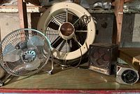 All four appliances grouped on shelf: Turbo-Aire fan, Cool Breeze fan, Pelonis heater, gray personal fan