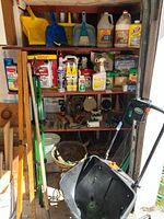 Full view of shelving with chemicals, tools, and front-positioned Scotts spreader