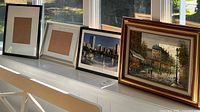 Four framed pieces lined up on bench
