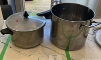Stainless stock pot and aluminum pressure cooker side by side