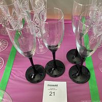 Mixed set of champagne flutes showing clear cut-crystal and black-stemmed glass pieces
