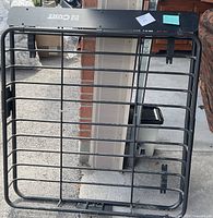 Front view of entire Curt roof cargo basket showing wind deflector and mounting brackets