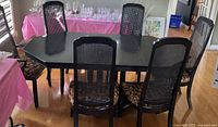 Dining table with six chairs around it