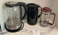 Group shot of two electric kettles and Bodum French press
