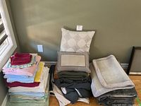 Overall lot with stacks of towels, pillows, blankets and rug