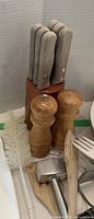 Knife block with 6 knives, salt and pepper grinders, dish brush, mallet, wooden spatula visible