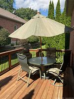 Full set on deck with umbrella open showing table, four chairs and umbrella