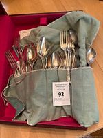 Flatware pieces in cloth roll inside chest