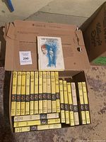 Open box showing most of the yellow-spine Nancy Drew hardcovers and one Whispering Statue on top