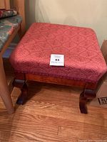 Front view showing upholstered seat, legs, and wood grain