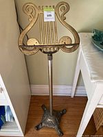 Full view of brass lyre music stand against wall