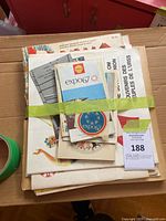 Top view of stacked Expo 67 literature bundled with green tape in cardboard box