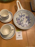 Top view of skillet, teacups and saucers showing pattern and condition
