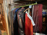 Wide view of rack showing multiple garment bags and fringe costume piece