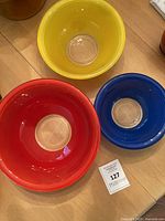 Top view of yellow, red and blue Pyrex bowls showing clear bottoms
