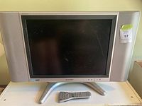 Front view of Sharp Aquos LCD TV with remote on stand