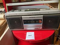 Front view showing speakers, cassette deck, tuner scale and controls