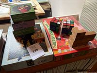 Overall group view of puzzles including jigsaw boxes, two Rubik’s cubes, wooden puzzles