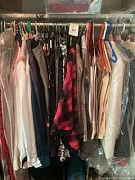 hanging rack showing variety of blouses, jackets, dresses and coats