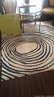 Full view of rug showing concentric oval design under small table