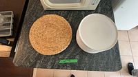Stack of white plates and woven placemat on countertop
