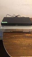 Two stacked units: black Sony player on top of silver Samsung recorder