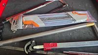 Group view of hacksaw, sealed Stihl file pack, Husky tool, and brass-tipped rod