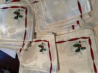 Stack of ivory holly-pattern napkins showing motif and hem
