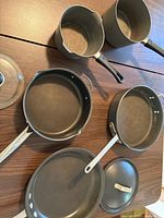 Group shot of five nonstick pans and pots with one glass lid