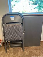 Table and folded chairs leaned against wall