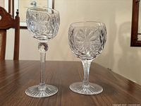Tall cordial and wine goblet side by side showing height and pattern comparison
