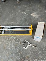 Tile cutter, Kreg jig box, locking clamp on concrete floor