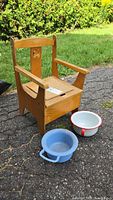 Wooden child’s potty chair with both pots in front