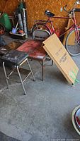 card table, two chairs, stool, box for drying rack visible