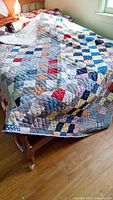 Full view of quilt on bed showing overall pattern and colours