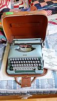 Imperial portable typewriter in open brown case on bed