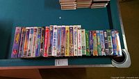 Full row of approximately 28 VHS tapes on table