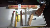Group shot of all instruments and accessories laid out including metronome, flutophones, mouthpiece, whistle, miniature harmonica and boxed music stand