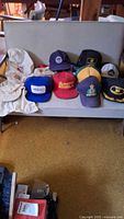 All hats laid out on loveseat